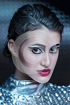 Portrait of young cyber woman in silver futuristic costume with bright makeup.
