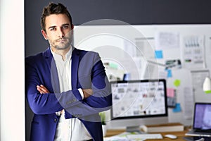 Portrait of young designer in front of laptop and computer while working.