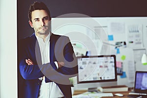 Portrait of young designer in front of laptop and computer while working.