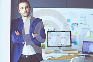 Portrait of young designer in front of laptop and computer while working.