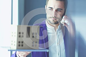 Portrait of young designer in front of laptop and computer while working.