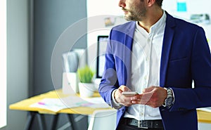 Portrait of young designer in front of laptop and computer while working.