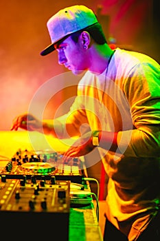 Portrait of Young DJ playing mixing music at night