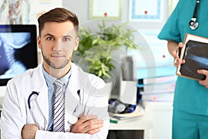 Portrait of a young doctor in a clinic with an assistant