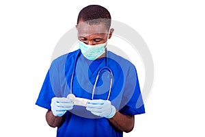 Portrait of a young doctor holding a pack of tablets