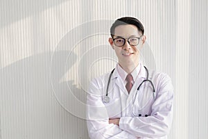 Portrait of young doctor with stethoscope office wall background.