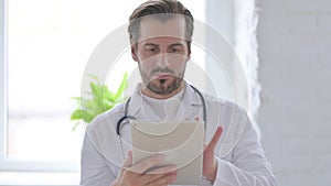 Portrait of Young Doctor using Tablet in Office
