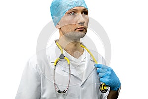 Portrait of a young doctor in a white coat on a black background. A doctor in blue gloves and with a medical stethoscope around