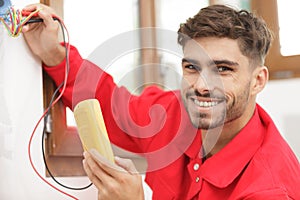 portrait young electrician using multimeter