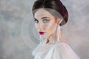 Portrait of a young elegant brunette bride with a stylish hairstyle