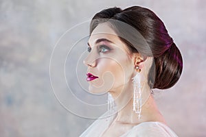 Portrait of a young elegant brunette bride with a stylish hairstyle