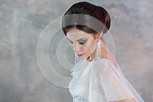 Portrait of a young elegant brunette bride with a stylish hairstyle.