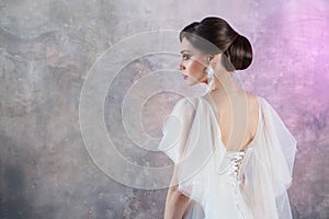 Portrait of a young elegant brunette bride with a stylish hairstyle.