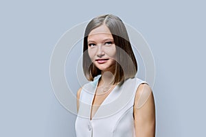 Portrait of young elegant business woman, on gray studio background