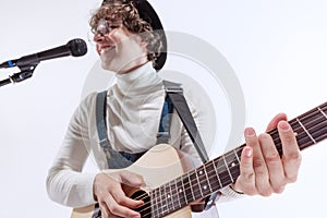 Portrait of young emotiona man, musician playing acoustic guitar and singing. Concept of art, music, style and creation photo