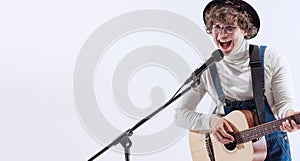 Portrait of young emotiona man, musician playing acoustic guitar and singing. Concept of art, music, style and creation photo