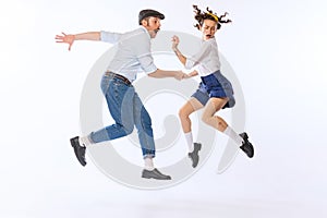 Portrait of young emotive couple, man and woman, dancing retro dance isolated over white studio background. Ralaxation