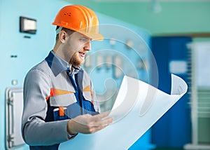 Portrait of young engineer working with blueprint
