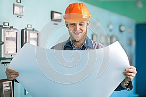 Portrait of young engineer working with blueprint