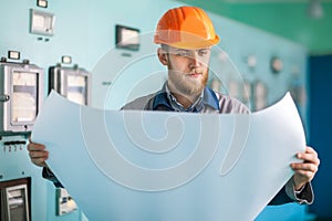 Portrait of young engineer working with blueprint