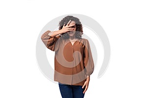 portrait of a young european curly woman with curled hair on a curling iron in a brown blouse isolated on a white