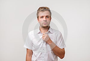 Portrait of young european man with sad face expression isolated on gray background