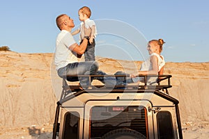 Retrato joven familia sobre el auto techo 