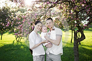 Portrait of a young family with a child. Happy young family spending time outdoor on a summer day. Happiness and harmony