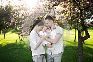 Portrait of a young family with a child. Happy young family spending time outdoor on a summer day. Happiness and harmony