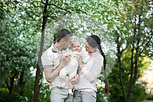 Portrait of a young family with a child. Happy young family spending time outdoor on a summer day. Happiness and harmony