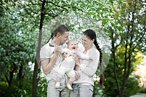 Portrait of a young family with a child. Happy young family spending time outdoor on a summer day. Happiness and harmony