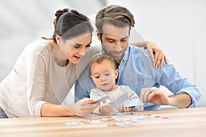 Portrait of young family playing cards