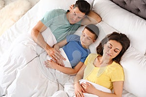 Portrait of young family sleeping in bed