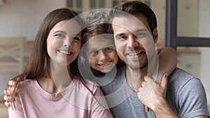 Portrait of young family with small son hugging