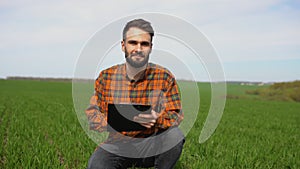 Portrait of young farmer at green agriculture field