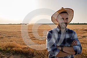 Portrait of young farmer standing in field during harvest