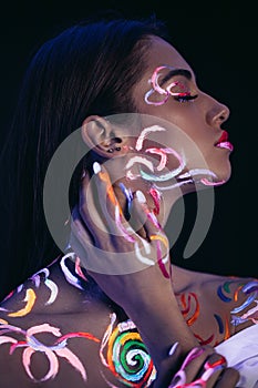 Portrait of young fashion model with fluorescent body art