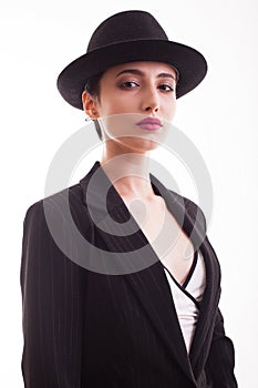 Portrait of young fashion model with a stylish hat posing in studio over white background