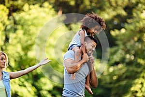 Portrait of young father carrying his daughter on his back