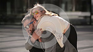 Portrait of young father carrying his daughter on his back. Family having a lot of fun spending father`s day together.