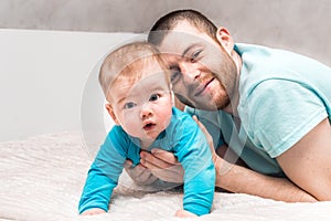 Portrait of a young father with his son in blue clothes. Father`s day concept