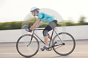 portrait of young female athlete racing on a bike. motion blurred image