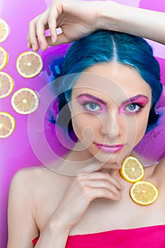 Portrait of young female in bathtub with pink water