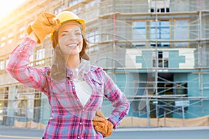 Portrait of Young Female Construction Worker Wearing Gloves, Hard Hat and Protective Goggles at Construction Site.