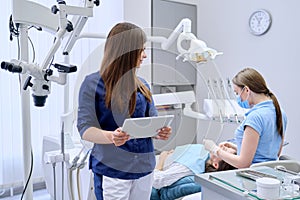 Portrait of young female doctor dentist with digital tablet in dental office