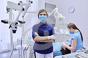 Portrait of young female doctor dentist in medical face mask in dental office