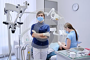 Portrait of young female doctor dentist in medical face mask in dental office