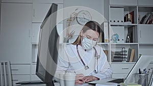 Portrait of young female doctor in face mask talking in clinic office