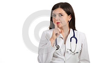 Portrait of young female doctor showing shh sign, silence.