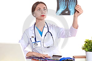 Portrait of young female doctor sitting at desk in hospital